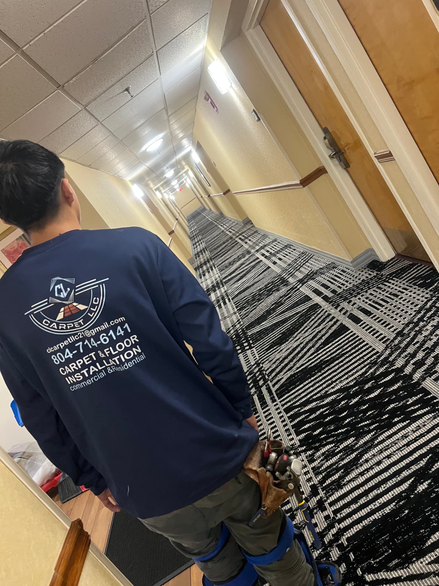 Patterned carpet tile being installed in a hotel corridor