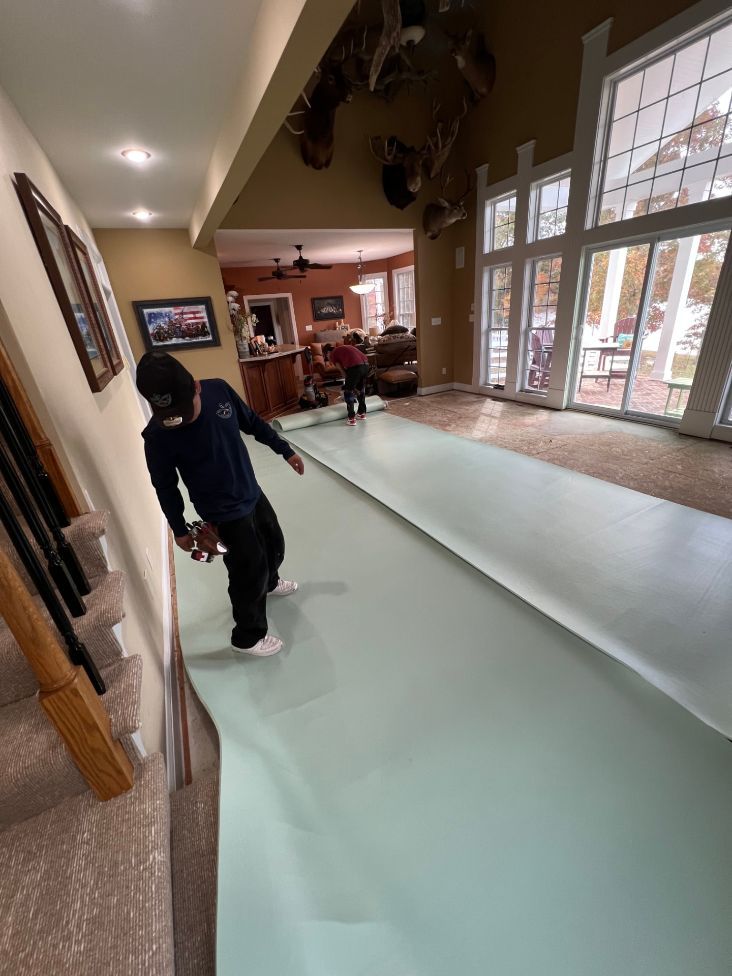 Installers rolling out new carpet padding in a home